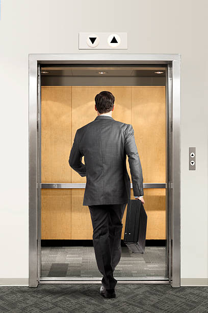 businessman-walking-confidently-into-elevator-picture-id612862770